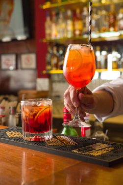 Aperol e Old Fashioned sendo finalizados no balcão do bar da Churrascaria Tertúlia
