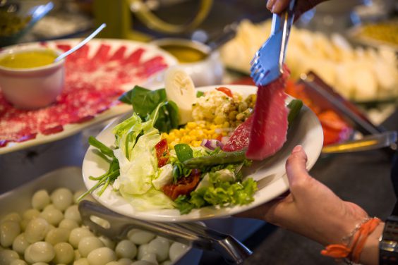 Prato sendo servido no buffet de saladas da Churrascaria Tertúlia contendo rosbife, palmito, aspargos, entre outros.